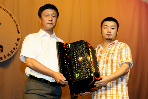 Ping Deng on behalf of Hohner China presents a Hohner accordion to the Harbin Normal University.