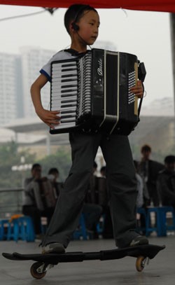 Small accordion player Side play and sing at the skateboard